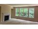 Spacious living room features a fireplace, large windows, and neutral carpeting at 5804 Claribel Ct, Raleigh, NC 27612