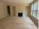 Bright living room with a fireplace, large windows, and neutral carpeting at 5804 Claribel Ct, Raleigh, NC 27612