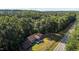 Scenic aerial of a wooded property featuring a house with a deck, highlighting its secluded location at 5900 Ebenezer Church Rd, Raleigh, NC 27612