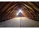 View of an unfinished attic with wooden beams and rafters at 5900 Ebenezer Church Rd, Raleigh, NC 27612