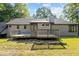 View of back exterior with deck and chimney, surrounded by trees at 5900 Ebenezer Church Rd, Raleigh, NC 27612
