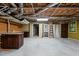 Spacious unfinished basement with exposed ceiling, a utility sink, doors, and a window at 5900 Ebenezer Church Rd, Raleigh, NC 27612