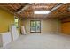 Spacious unfinished basement with utility sink, exposed ceiling, sliding door, and window at 5900 Ebenezer Church Rd, Raleigh, NC 27612