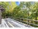 The home features a large deck with wood railings perfect for enjoying the lush, wooded surroundings at 5900 Ebenezer Church Rd, Raleigh, NC 27612