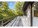 Expansive deck runs along the side of this house, with views of the surrounding trees at 5900 Ebenezer Church Rd, Raleigh, NC 27612