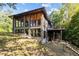 Rustic home featuring large windows, a deck, and lush greenery, creating a serene and inviting atmosphere at 5900 Ebenezer Church Rd, Raleigh, NC 27612