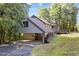 Exterior view showcasing the home's unique design, carport, and beautiful natural setting at 5900 Ebenezer Church Rd, Raleigh, NC 27612