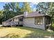Cozy home with large windows and a chimney, nestled amongst lush trees and greenery at 5900 Ebenezer Church Rd, Raleigh, NC 27612