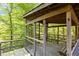 Exterior view of a screened in wooden porch surrounded by green trees at 5900 Ebenezer Church Rd, Raleigh, NC 27612