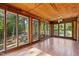 Bright sun room with wood paneled walls and multiple large windows at 5900 Ebenezer Church Rd, Raleigh, NC 27612