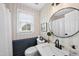 Modern bathroom with striped walls, elegant fixtures, round mirror and ample natural light from the window at 6 W Canterbury Ct, Wendell, NC 27591