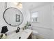 Stylish powder room featuring a modern sink, round mirror, and neutral decor at 6 W Canterbury Ct, Wendell, NC 27591