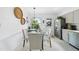 Bright dining area with glass table and chairs adjacent to the kitchen, featuring decorative wall art at 6 W Canterbury Ct, Wendell, NC 27591