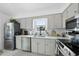 Galley kitchen with white cabinets, stainless steel appliances, and a white subway tile backsplash at 6 W Canterbury Ct, Wendell, NC 27591