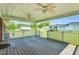 Relaxing covered back porch featuring a wooden deck with ceiling fans and peaceful views at 6080 Us 421 N, Lillington, NC 27546