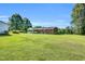 Spacious backyard featuring a manicured lawn, mature trees, and a charming covered patio at 6080 Us 421 N, Lillington, NC 27546