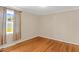This bedroom features a wood floor and one window with curtains overlooking the yard at 6080 Us 421 N, Lillington, NC 27546