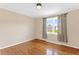 This bedroom features a wood floor and one window with curtains overlooking the neighborhood at 6080 Us 421 N, Lillington, NC 27546