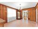 Dining room featuring wood paneling and traditional chandelier and view to living room at 6080 Us 421 N, Lillington, NC 27546