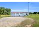 Spacious detached three car garage with white doors and large gravel parking area at 6080 Us 421 N, Lillington, NC 27546