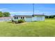 View of the outbuildings, including garages and sheds, on a well-maintained grassy lot at 6080 Us 421 N, Lillington, NC 27546
