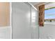 The shower features a sliding glass door, patterned curtains, and a view out the window at 6080 Us 421 N, Lillington, NC 27546