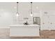 Modern kitchen with a central island, white cabinetry, and stainless steel refrigerator at 615 Daniels St # 215, Raleigh, NC 27605