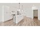 Bright, open kitchen with white cabinets, stainless steel appliances, and hardwood floors at 615 Daniels St # 215, Raleigh, NC 27605