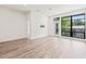 Bright, open living space with wood floors, large windows, and a door to the outside at 615 Daniels St # 215, Raleigh, NC 27605