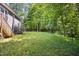 Expansive, well-maintained backyard with lush green grass, mature trees, and a home exterior visible at 619 E Hatterleigh Ave, Hillsborough, NC 27278