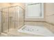 Well-lit bathroom with a glass shower and jacuzzi tub at 619 E Hatterleigh Ave, Hillsborough, NC 27278