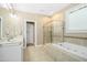 Bright bathroom featuring double sinks, a jacuzzi tub, and glass shower at 619 E Hatterleigh Ave, Hillsborough, NC 27278
