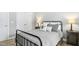 Comfortable bedroom features hardwood floors and a black metal bed frame at 619 E Hatterleigh Ave, Hillsborough, NC 27278