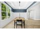 Bright dining room with large windows and modern light fixture at 619 E Hatterleigh Ave, Hillsborough, NC 27278