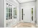 Bright foyer with a white front door, french doors, and beautiful luxury vinyl plank flooring at 619 E Hatterleigh Ave, Hillsborough, NC 27278