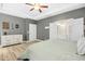 Spacious main bedroom featuring a tray ceiling, ceiling fan, dresser, and connecting bathroom at 619 E Hatterleigh Ave, Hillsborough, NC 27278