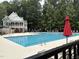 Exterior view of the pool and pool house, surrounded by seating and umbrellas at 619 E Hatterleigh Ave, Hillsborough, NC 27278