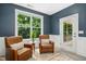 Cozy sun room featuring two leather armchairs and view of the backyard at 619 E Hatterleigh Ave, Hillsborough, NC 27278