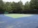 Outdoor tennis court with net, bench, and enclosed by a dark privacy fence at 619 E Hatterleigh Ave, Hillsborough, NC 27278