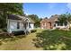 Backyard featuring a well-maintained lawn and a charming house at 624 Powhatan Dr, Fuquay Varina, NC 27526