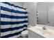 Bathroom with blue striped shower curtain, white sink and toilet at 624 Powhatan Dr, Fuquay Varina, NC 27526