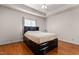 Spacious bedroom with hardwood floors, a ceiling fan, and a dark wood bed frame with storage underneath at 624 Powhatan Dr, Fuquay Varina, NC 27526