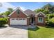 Charming red brick home with a two-car garage and a well-manicured lawn at 624 Powhatan Dr, Fuquay Varina, NC 27526