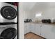 Laundry room with stacked washer dryer, sink, and neutral cabinets at 624 Powhatan Dr, Fuquay Varina, NC 27526