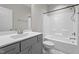 Bathroom with a single vanity, toilet, and bathtub with shower, designed with a neutral color palette at 6624 Vestal St, Wake Forest, NC 27587