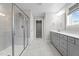 Modern bathroom with glass enclosed shower, gray cabinets, and bright white counters at 6624 Vestal St, Wake Forest, NC 27587