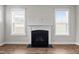 Living room fireplace and mantle with built-in features, surrounded by natural light from large windows at 6624 Vestal St, Wake Forest, NC 27587