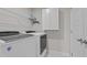 Functional laundry room with modern washer and dryer, storage cabinets, and tile flooring at 6624 Vestal St, Wake Forest, NC 27587