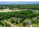 An aerial view showcases a neighborhood surrounded by verdant trees, and meticulously maintained landscaping at 8140 Consella Way, Willow Springs, NC 27592