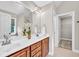 Bright bathroom with double vanity, large mirror, floral accent, and doorway to toilet and shower area at 8140 Consella Way, Willow Springs, NC 27592